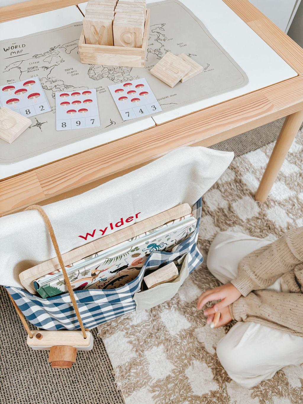 Blue gingham personalised chair bag on a children's chair with embroidery, ideal for organized learning spaces.