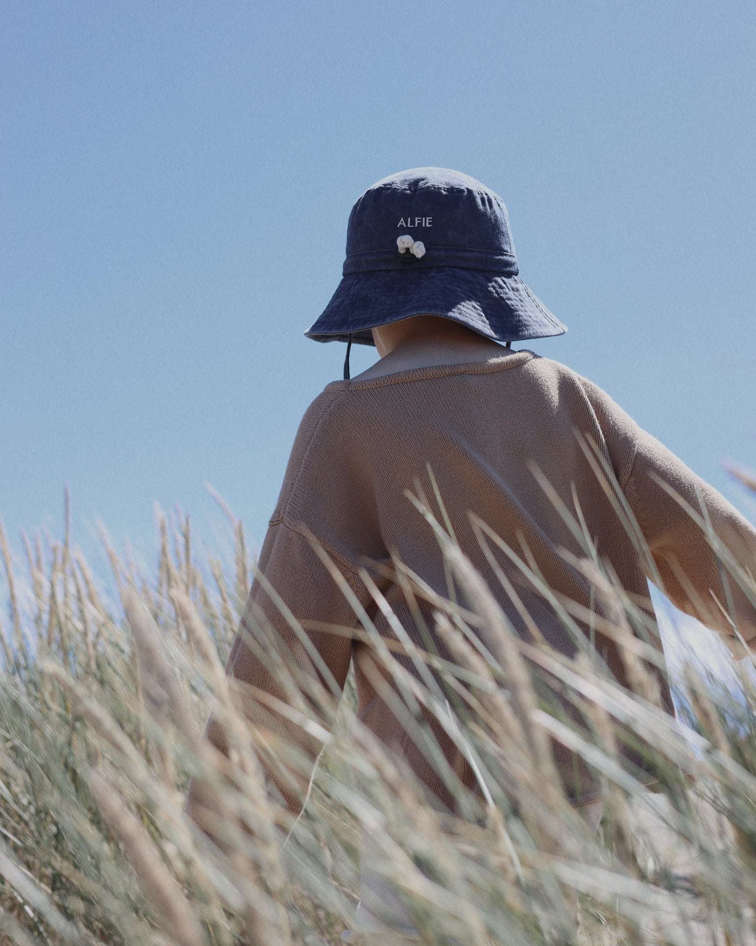 Child wearing Digger Personalised Bucket Hat in field.