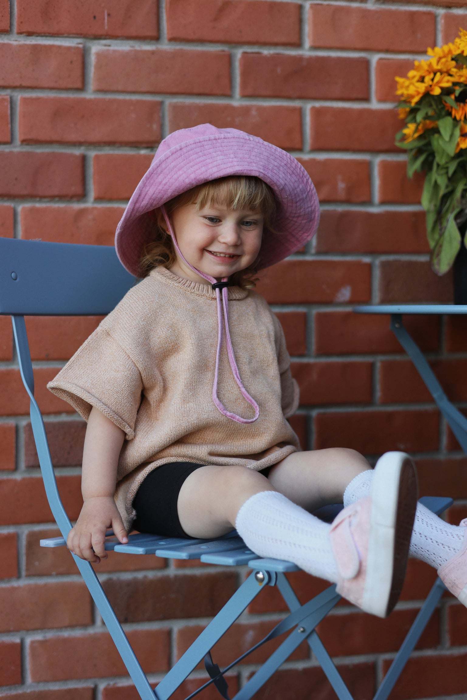 Toddler wearing a pink customised bucket hat made of 100% washed cotton.
