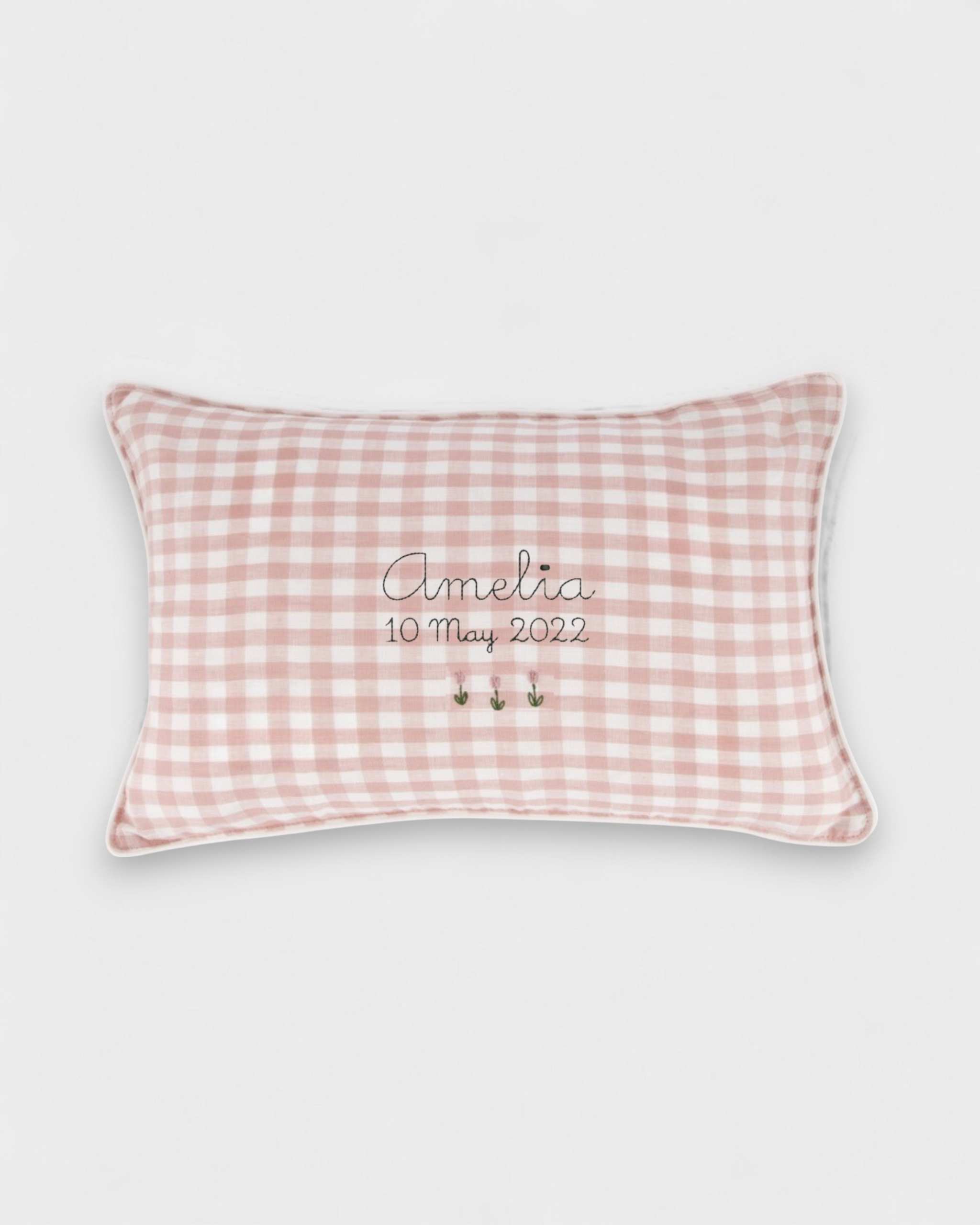 Botanical cushion with pink gingham linen and embroidered floral design.