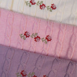 Merino baby blanket with rosette design and embroidery in soft wool.