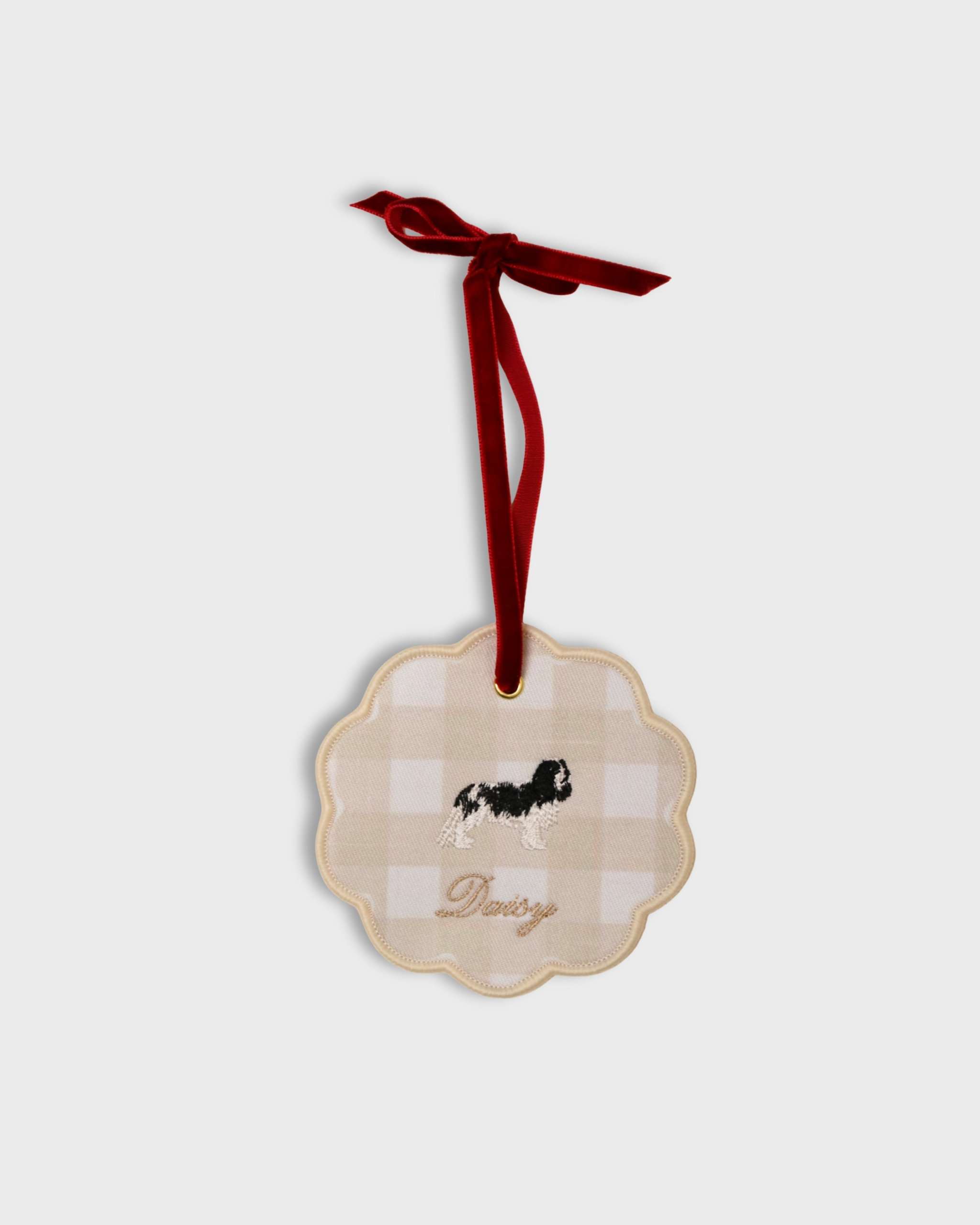 Personalised pet ornament with embroidered dog design and name on beige gingham fabric with red velvet hanging ribbon