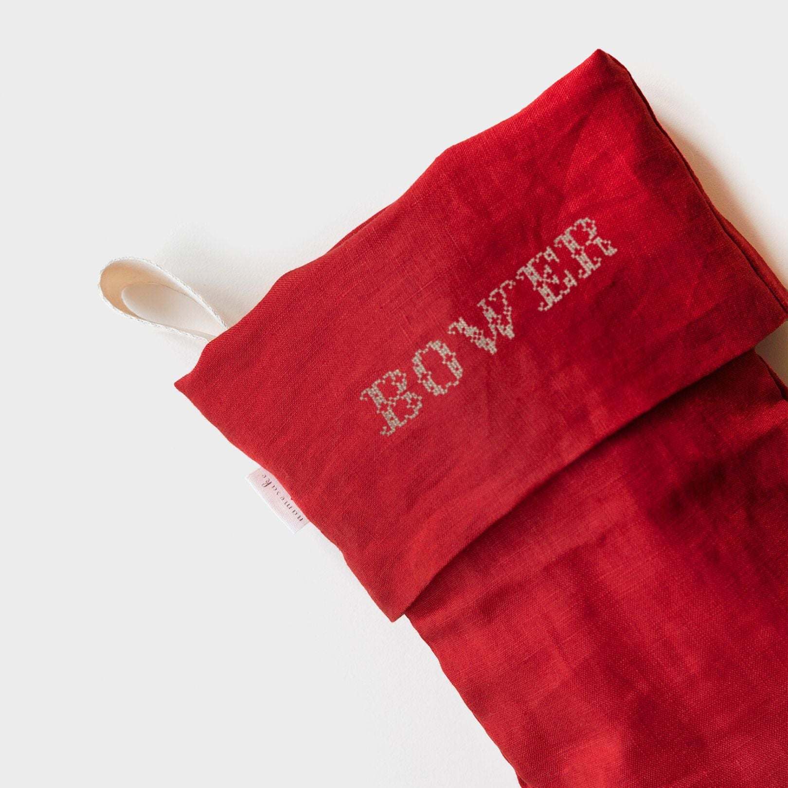 Red linen Christmas stocking with Nordic cross stitch name embroidery and cotton herringbone loop