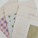 Personalised chair bags in pink and purple gingham design, embroidered with names, perfect for kids' study areas.