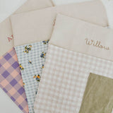 Personalised chair bags in pink and purple gingham design, embroidered with names, perfect for kids' study areas.