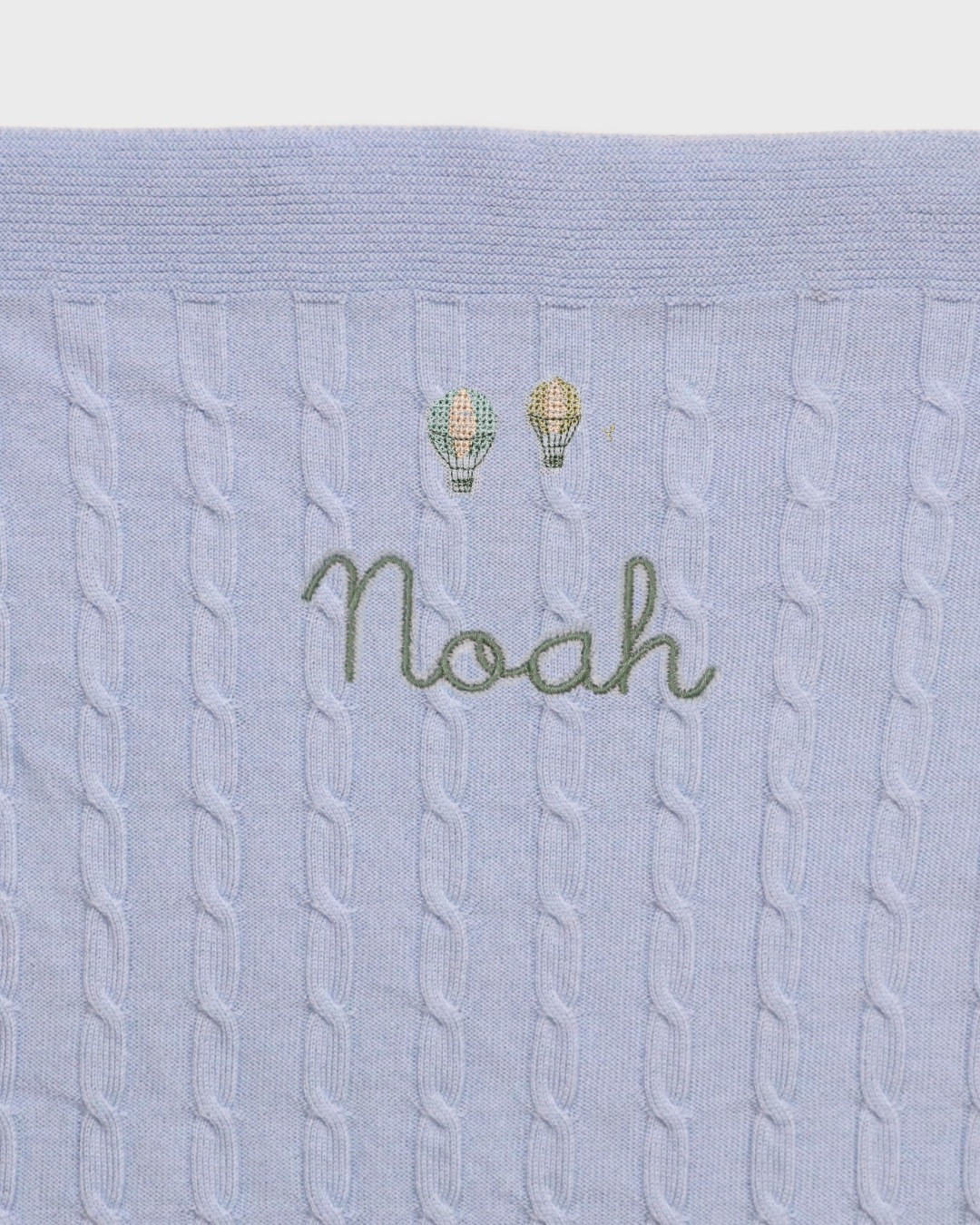 Merino wool baby blanket with balloons design and embroidered personalisation.