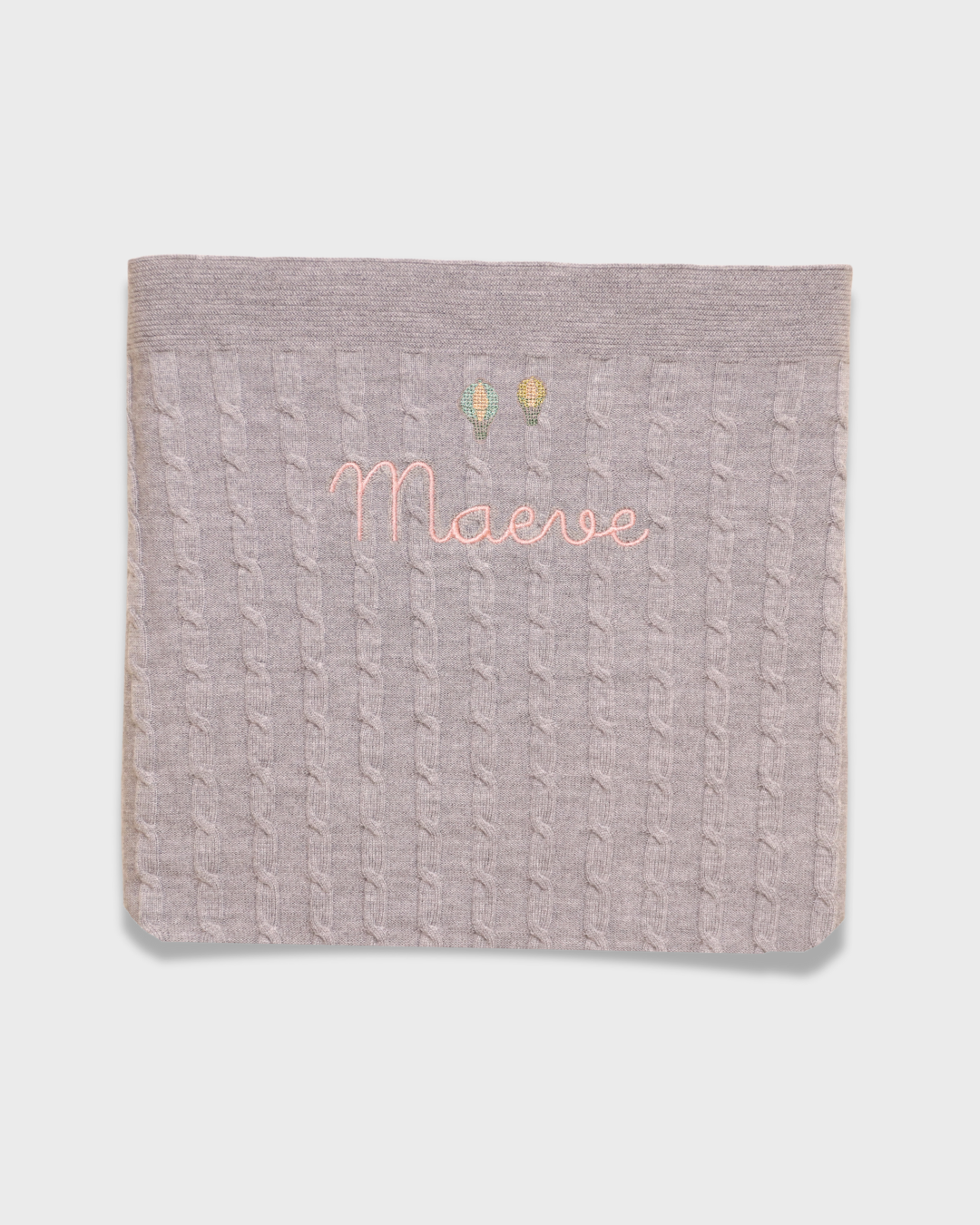 Merino baby blanket with embroidered hot air balloons design and personalized name.