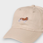 Beige baseball cap with embroidered King Charles Spaniel design and personalized embroidery option.