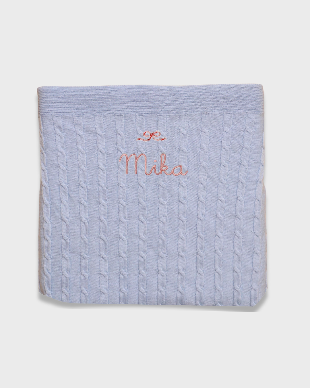 Merino baby blanket with bow design and personalized embroidery.