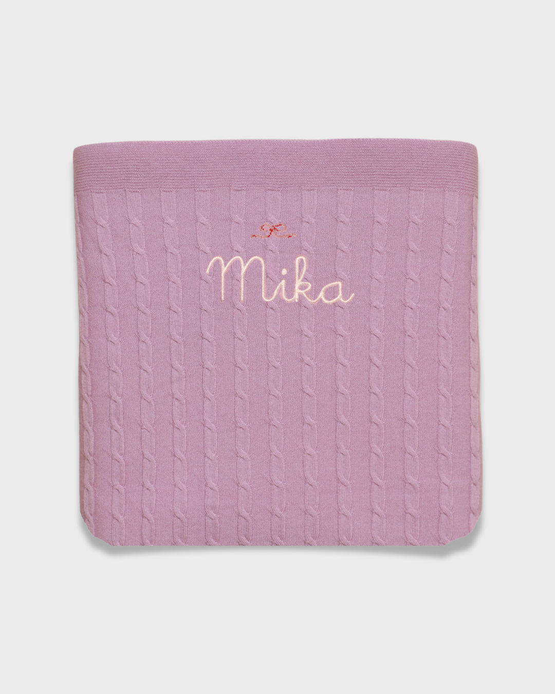 Merino baby blanket with bow design and embroidered personalisation.