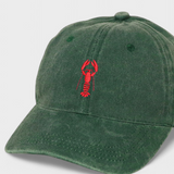 Green personalised hat with red hand-drawn lobster embroidery on front, made of 100% washed cotton, classic baseball fit.