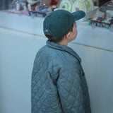 Tennis personalised hat with embroidery design, worn by a child in a stylish quilted jacket.