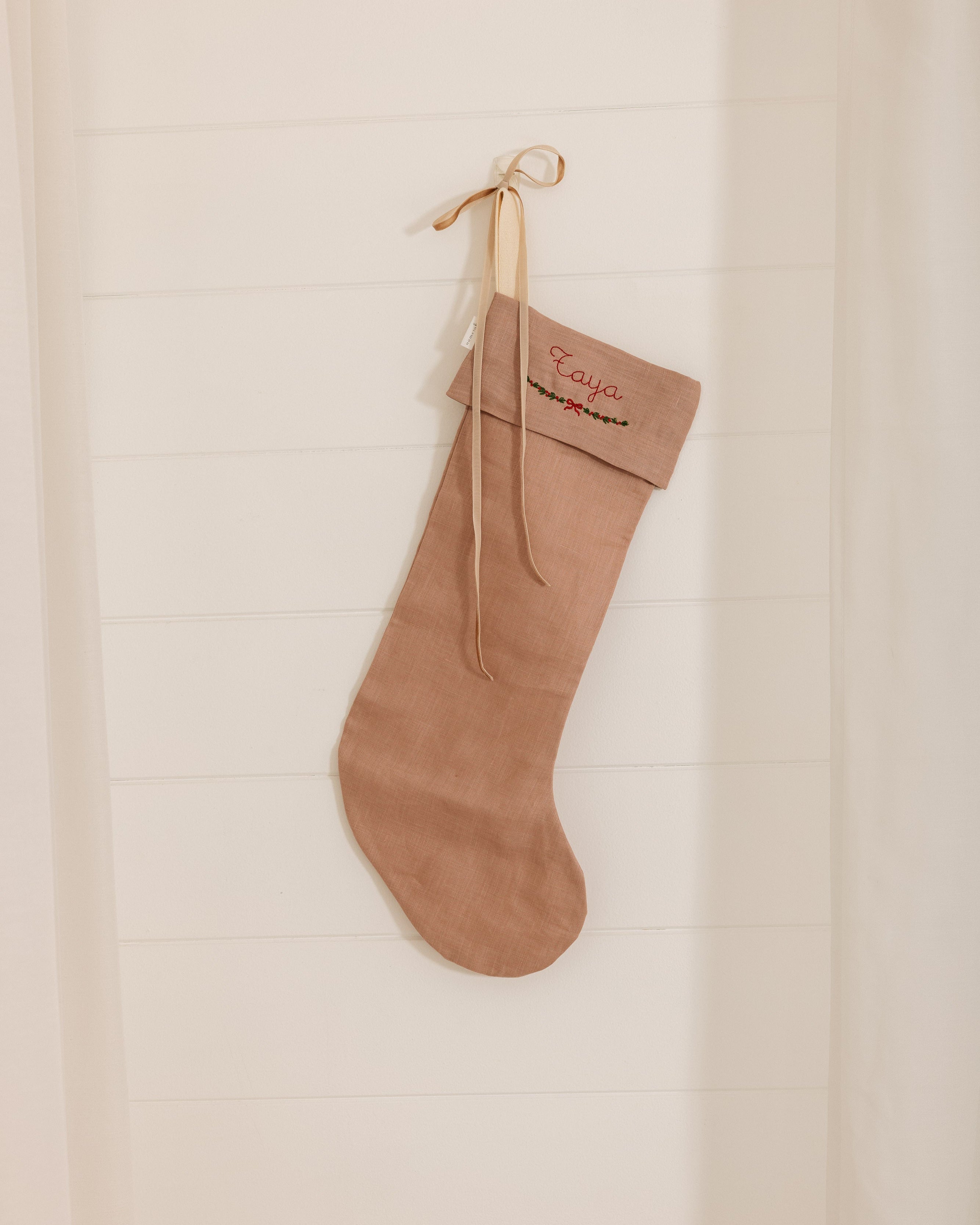  handmade personalized linen Christmas stocking in natural color hanging on wall