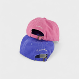 Airplane personalised hats in pink and blue with custom embroidered names, made of 100% washed cotton.