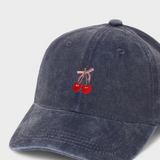 Navy blue personalised hat with embroidered cherries and pink bow on the front.