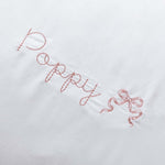 Organic cotton pillowcase with white scalloped edge and personalized embroidery.