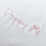 Organic cotton pillowcase with white scalloped edge and personalized embroidery.