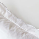 Organic cotton pillowcase with white scalloped edge embroidery.