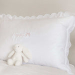Organic cotton pillowcase with white scalloped edge and customizable embroidery.