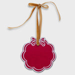 Red scalloped pet ornament with white embroidered bow and gold velvet hanging ribbon