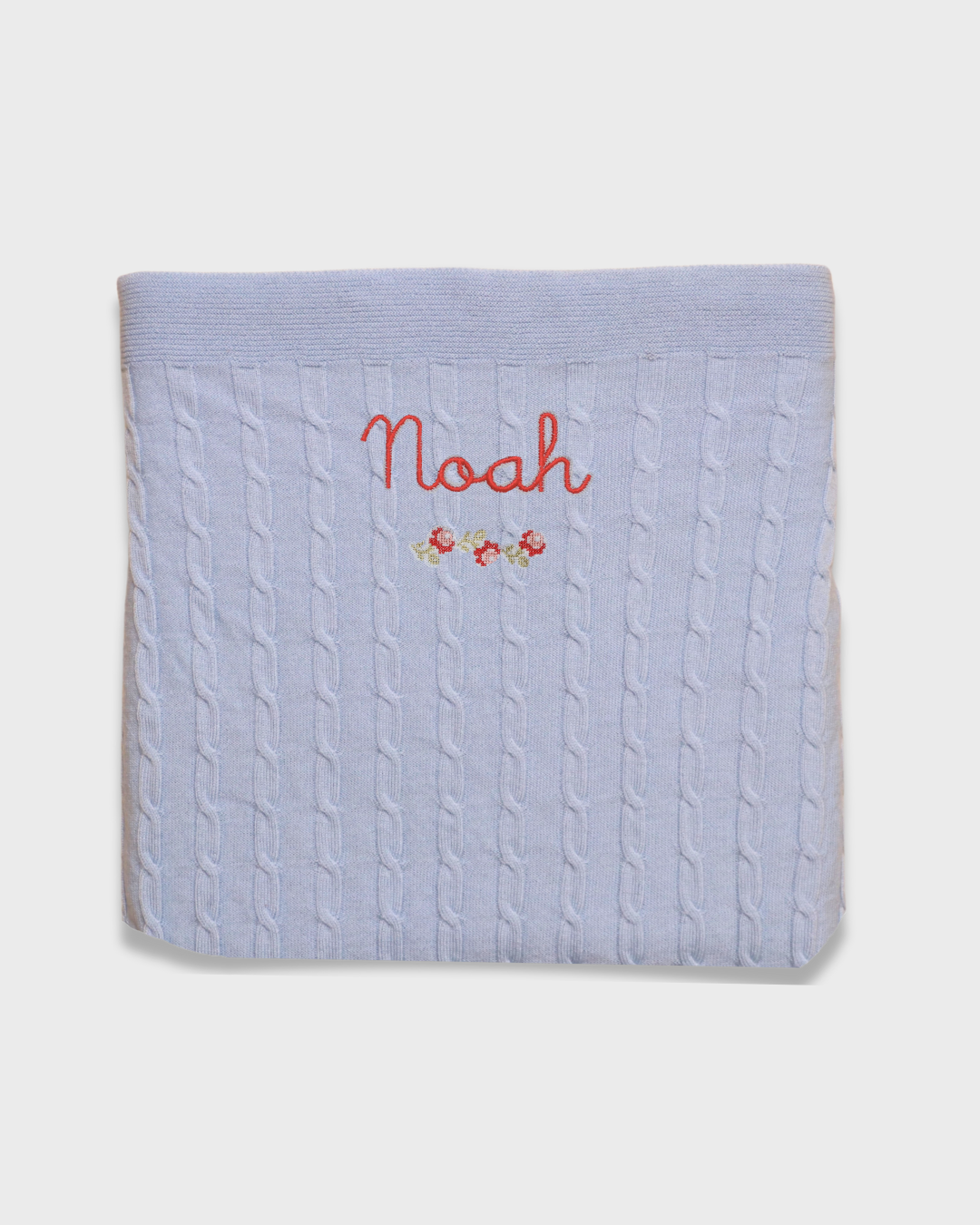 Merino baby blanket with rosette design and personalized embroidery.