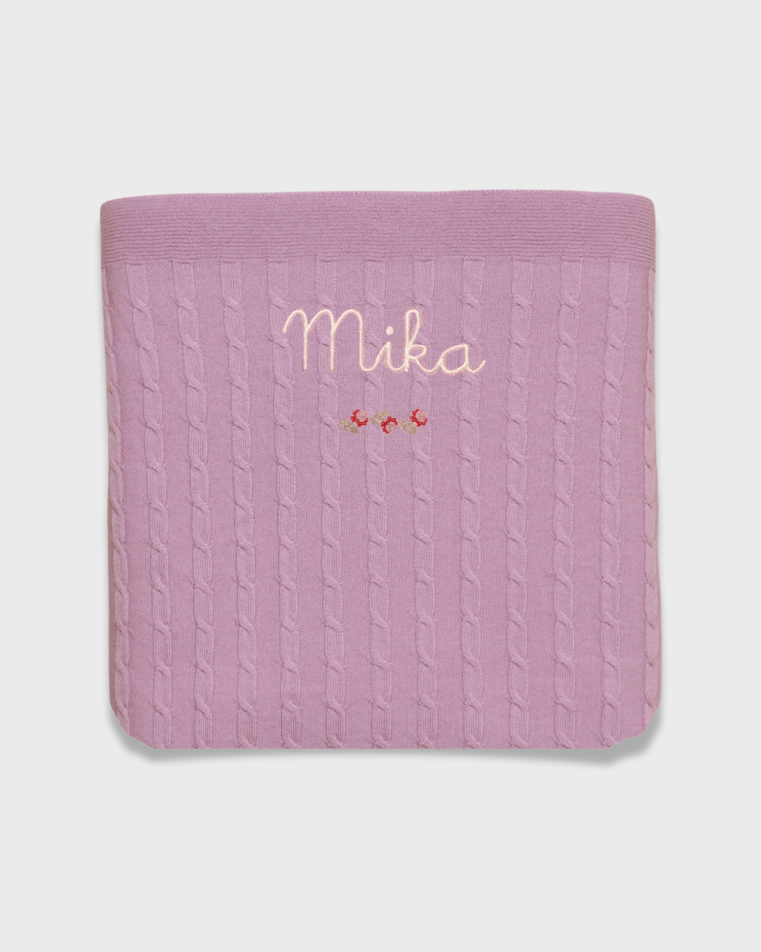 Merino baby blanket with rosette design, personalized embroidery, and vintage-inspired cross stitch.