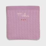 Merino baby blanket with rosette design, personalized embroidery, and vintage-inspired cross stitch.