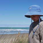 Customised bucket hat on a child at the beach, made of 100% washed cotton.