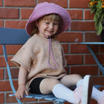 Toddler wearing a pink customised bucket hat made of 100% washed cotton.