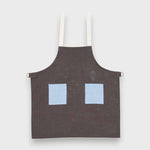 Kids blue on stone grey linen apron with embroidery and adjustable straps.